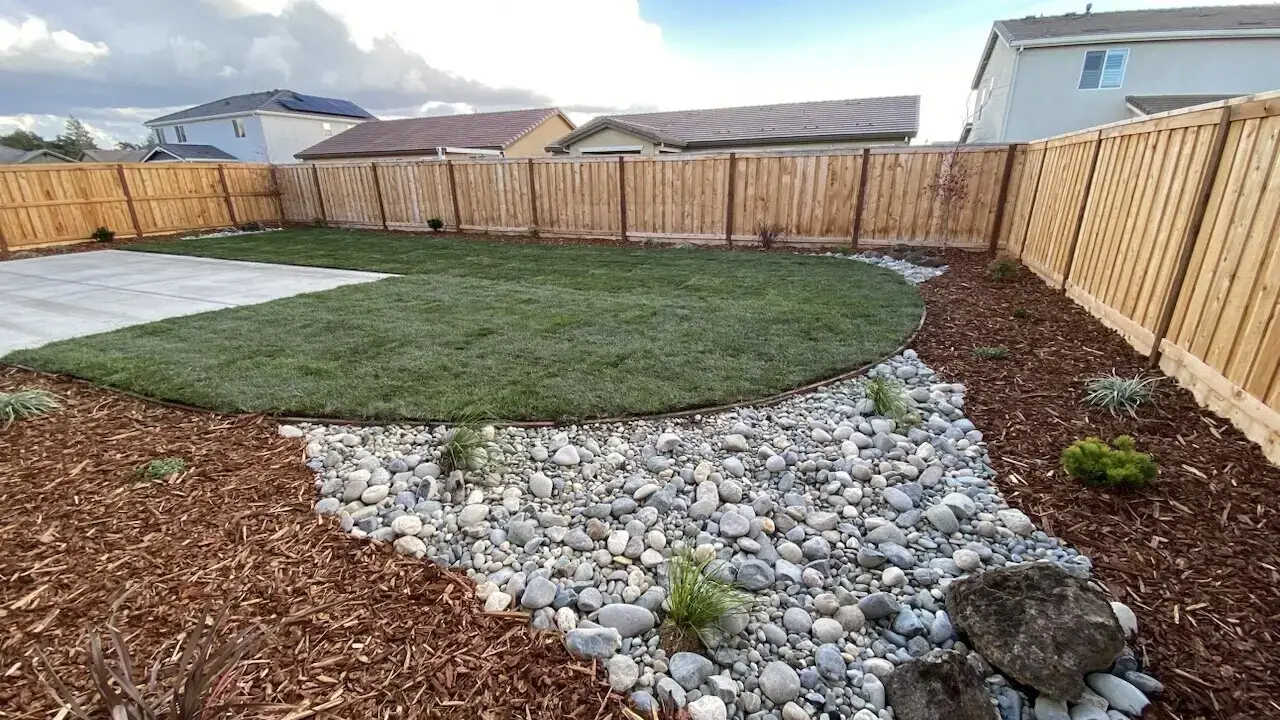 Backyard rock bed with low-water plantings by McGuire Earth Works