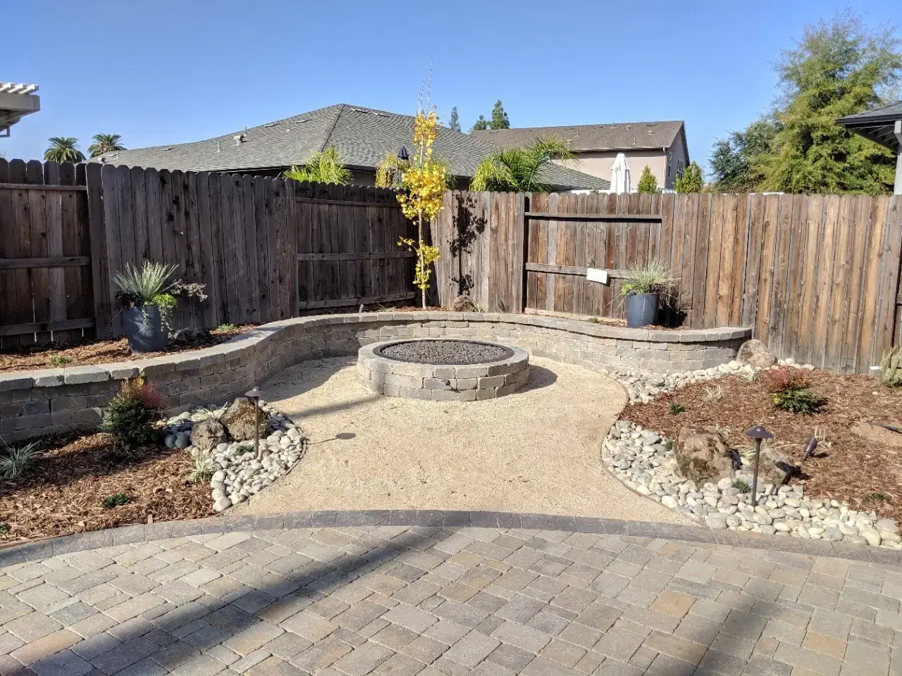 Hardscape fire pit patio with seating area by McGuire Earth Works